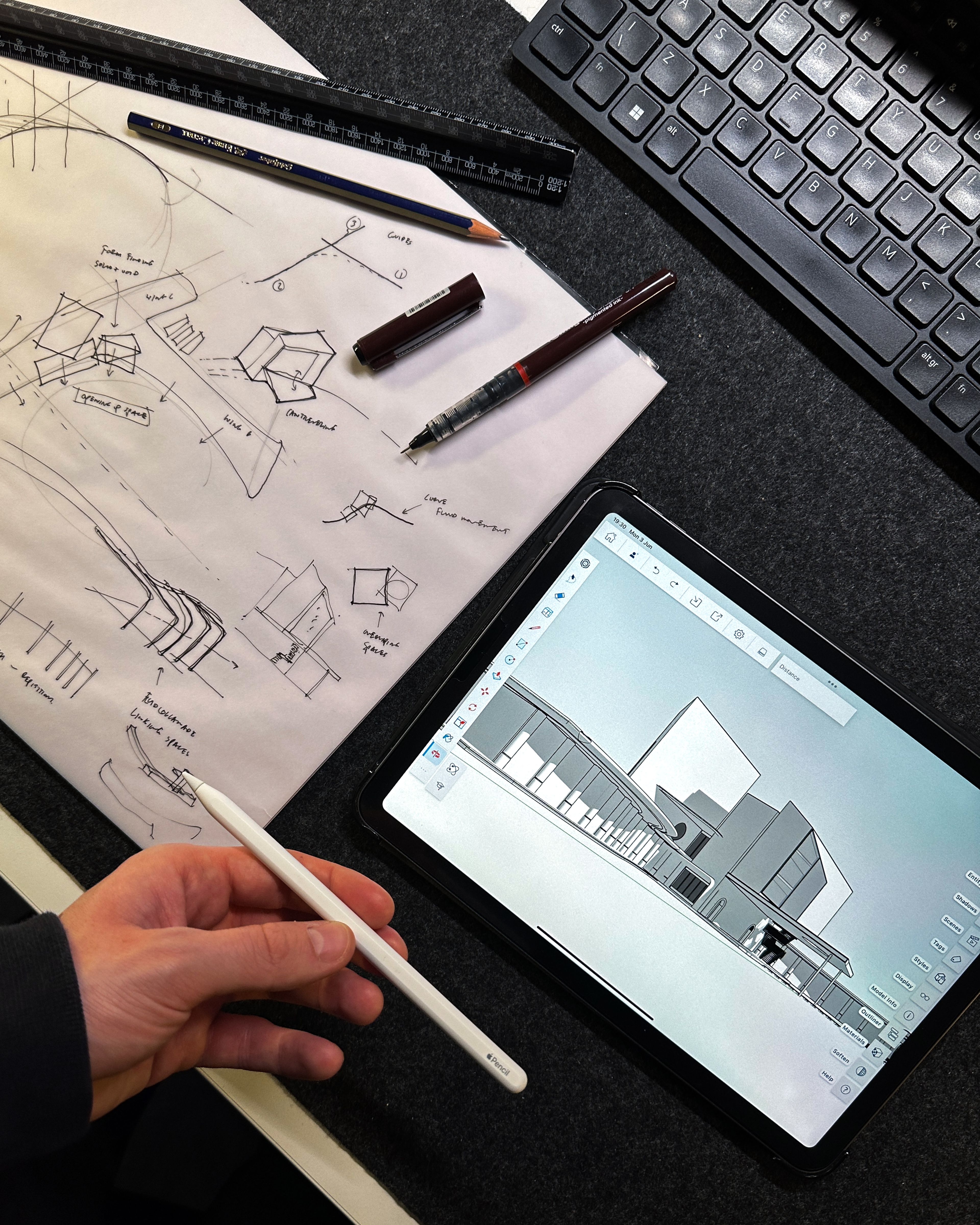 SketchUp model of a deconstructivist building on an iPad and sketches on paper.