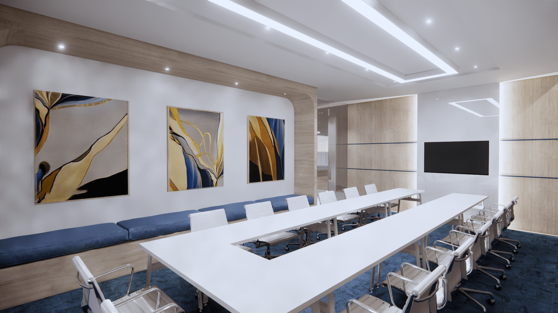 A commercial conference room with a large U-shaped table, a TV on the right wall, art and cushioned bench seating parallel to
