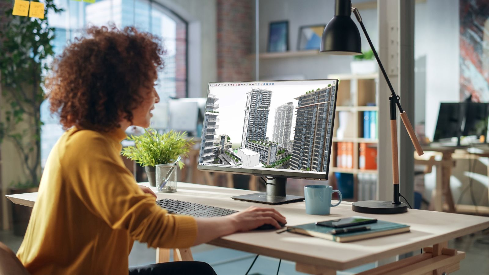 Woman working on a SketchUp model on a computer