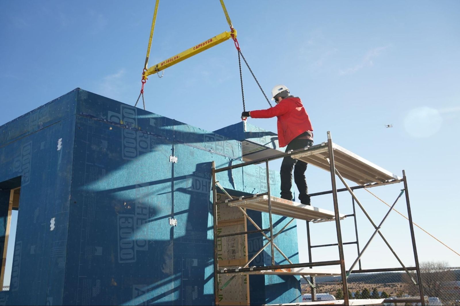 A worker installing B. PUBLIC Prefab roof panels.
