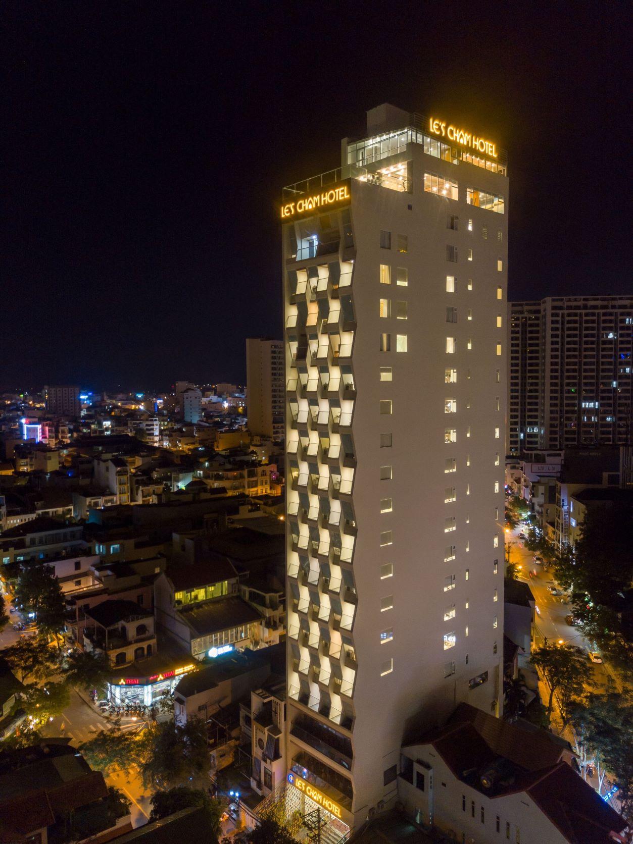 Le’s Cham Hotel stands out at night with its zigzag-fold windows.